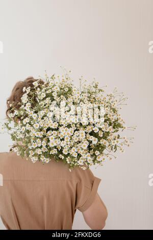 Portrait of young woman with bunch of daisies Stock Photo - Alamy