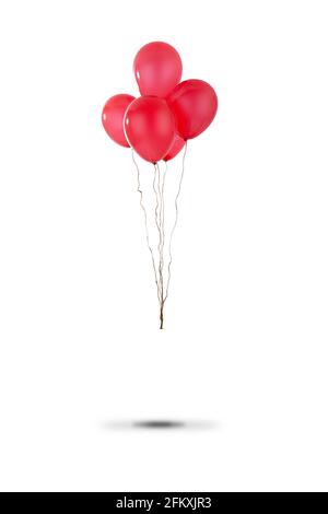 Small bunch of red party balloons tied with string floating above the ground and isolated on a white background Stock Photo