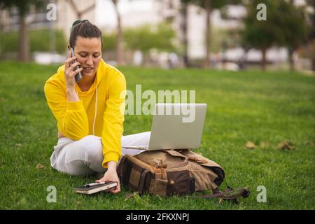 Spanish student talking on the phone while working with laptop Stock Photo