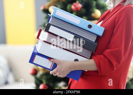 Woman is holding heavy stack of folders with documents. Stock Photo