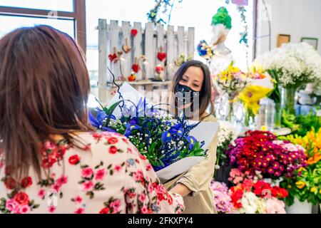 enterprising woman handing a bouquet of flowers to her client Stock Photo