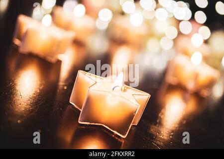 Relaxing Tealight In Star Shape With A Bokeh Of Several Candles Stock Photo