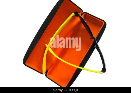 Pair of Dazzle sunglasses with yellow arms in sunglasses case with orange coloured lining set on white background Stock Photo