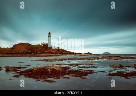 Long exposure of Turnberry Lighthouse at the famous golf course in Scotland from the rocks at low tide. Stock Photo