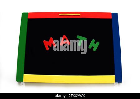 Wooden letters spell math on a black magnetic board.  Board is rimmed with primary colors. Stock Photo