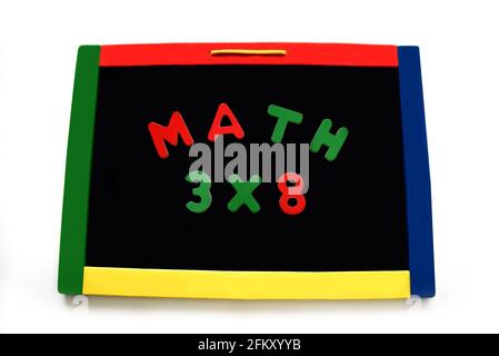 Wooden letters spell math and a multiplication problem on a magnetic board.  Board is rimmed with primary colors. Stock Photo
