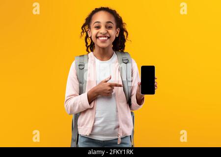 Black girl showing blank empty smartphone screen and pointing Stock Photo