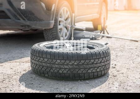 Replacing the wheel on the road by the driver. Replacement of tires on the car by a mechanic after balancing the wheels in close-up. The prepared whee Stock Photo