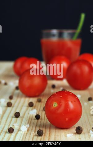 Fresh tomatoes, red tomatoes. Tomato juice freshly squeezed in a transparent glass. Stock Photo
