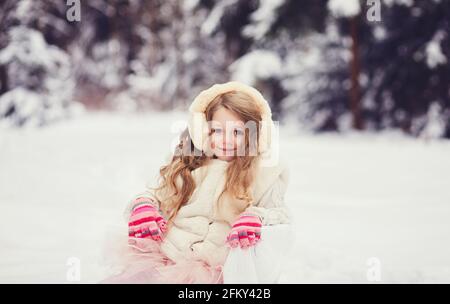 portrait of little girl in fur coat in snowy park Stock Photo