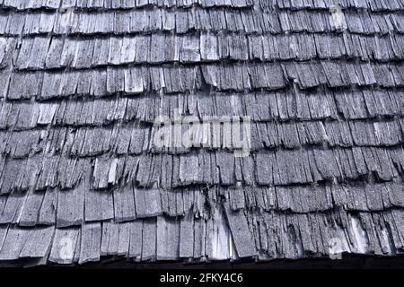 old broken wooden shingle texture; damaged traditional roof that needs repair Stock Photo