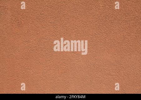 Terraсotta wall texture, background. Decor of brown textured coating. Structural plaster, rough, uneven surface in light-brown color. Modern exterior Stock Photo