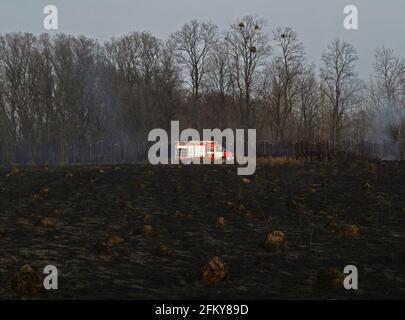 Kiev region, Ukraine – April 14, 2012: Fire engine. Black burnt earth. Conflagration. The fire that destroys forest, grass, and agricultural crops Stock Photo
