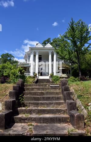 Beautiful antebellum home is beginning to fall into decline.  Steps are in need of upkeep and railing on second story balcony has broken rail. Stock Photo