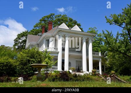 Beautiful antebellum house has four tall columns and beautiful architecture.  porch railing and yard is in need of repair and upkeep. Stock Photo