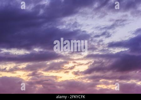 Sunset sky with clouds and sunbeams through wind clouds.  Stock Photo