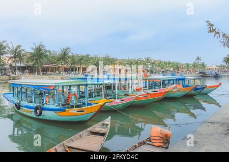 Vibrant, colourful, traditional Vietnamese tour boats moored along the Thu Bon River in quaint, picturesque Hoi An, Vietnam. Stock Photo