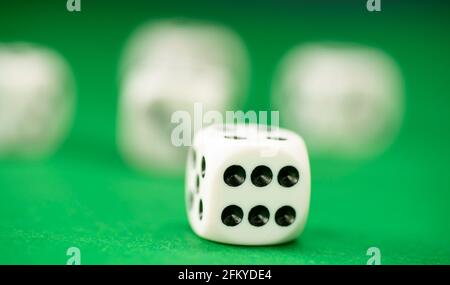 White dice on green felt table close up Stock Photo