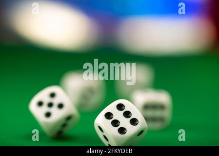 White dice on green felt table close up Stock Photo