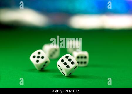 White dice on green felt table close up Stock Photo
