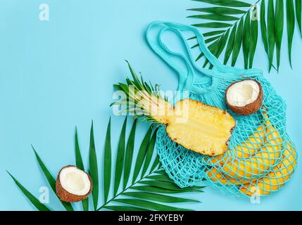 Tropical fruits and reusable cotton bag on blue summer background. Copy space, overhead. Stock Photo