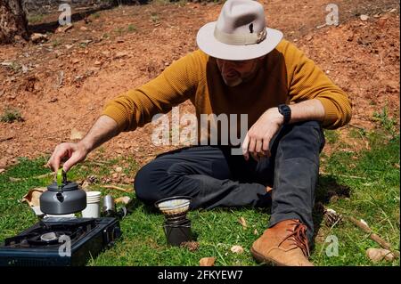 https://l450v.alamy.com/450v/2fkyew7/traveler-man-making-coffee-in-the-field-2fkyew7.jpg