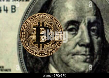 Spain. 04th May, 2021. In this Photo illustration, a Bitcoin is seen on a background of a one hundred dollars bill. Credit: SOPA Images Limited/Ģ����ý Live News Stock Photo