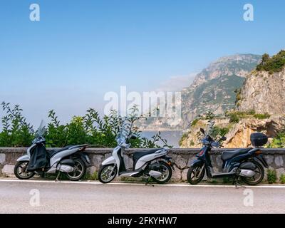 POSITANO, ITALY- JUNE, 14, 2019: morning shot of scooters parked by the road in the village of positano on the amalfi coast Stock Photo