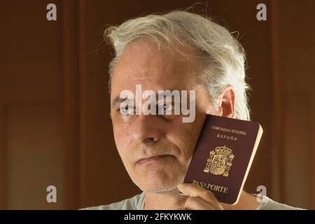 mature man thinking with a passport in hand Stock Photo