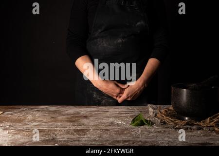 Lady standing behind floured table Stock Photo
