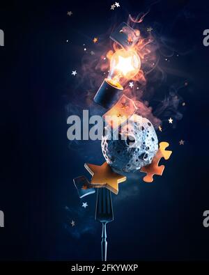 Lightbulb with stars, puzzles, and a tiny Moon on a fork, space travel still life, love of science concept Stock Photo