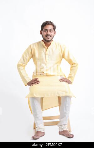 Young indian man in tradition wear and sitting on white background. Stock Photo