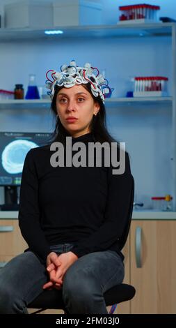 Researcher and patient with eeg headset looking at virtual display with touchscreen, virtual reality using medical inovation in neurological research lab. Scientists working with healthcare simulator Stock Photo