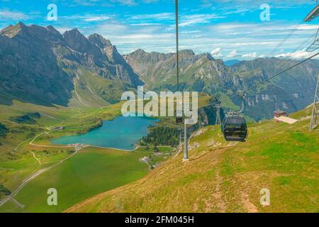Titlis, Engelberg, Switzerland - Aug 27, 2020: cable car on Engelberg valley with Truebsee lake. Cable cars to Titlis mountain of the Uri Alps Stock Photo