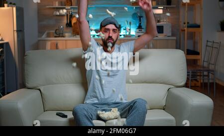 POV dissapointed upset angry man watching sport competition, favourite team loosing big championship. Soccer football fan expressing anger and frustration while watching TV. Slow motion shot Stock Photo