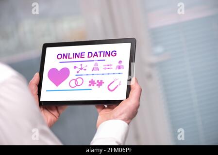 Online dating concept shown on a tablet held by a man Stock Photo