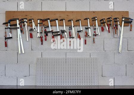 Set of professional tools hanging on white background Stock Photo