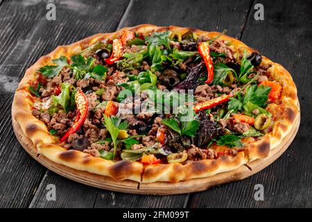 Fresh minced meat pizza with hot pepper and greens Stock Photo