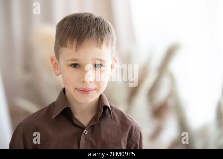 A boy of nine or ten years of European appearance is looking at the camera. Stock Photo