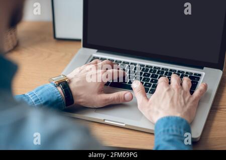 Close up picture of mans hands typing on a laptop Stock Photo