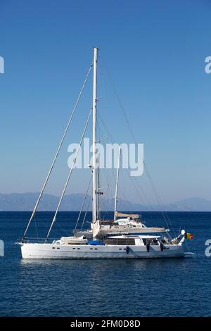 Yacht off the coast of Rhodes in Greece. The vessel is anchored on a calm sea. Stock Photo