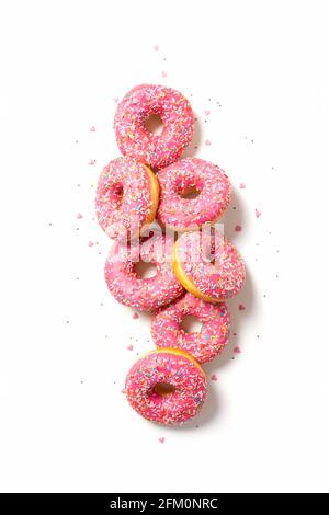 Amazing donuts isolated on white. Top view of yummy fresh homemade doughnuts. Light background. Decorated with confetti in shape of little hearts. Stock Photo