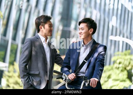 two asian business associates having a conversation in downtown of modern city Stock Photo