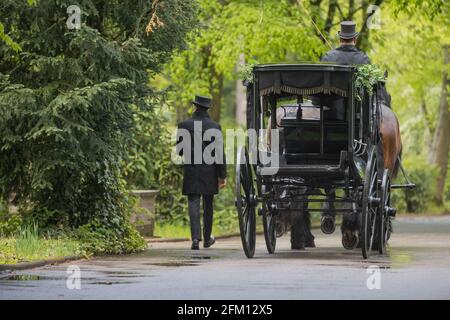 Cologne, Germany. 05th May, 2021. A horse-drawn carriage arrives for Willi Herren's funeral service at Melaten Cemetery. The actor and singer Willi Herren had died on April 20. Credit: Rolf Vennenbernd/dpa/Alamy Live News Stock Photo