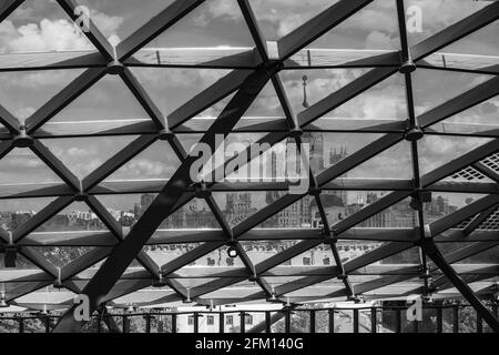 Glass roof with oval metal partitions. Shadow from the base on the grass. Stock Photo