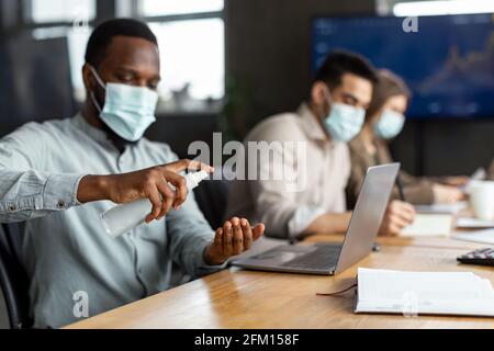 International workers wearing medical masks using sanitizer Stock Photo
