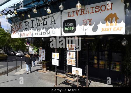 a pizza restaurant named "S.O.S. Pizza" with delivery services like Uber Eats and Just Eat in Paris, France Stock Photo