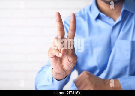 man hand showing victory gesture on white background  Stock Photo
