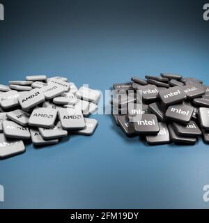 Logos of the competing tech companies Intel and AMD on heaps on a table. Copy space. Stock Photo