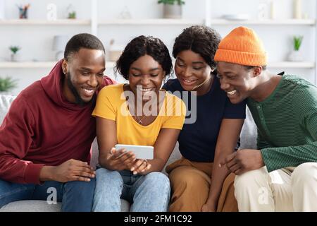 Happy african american friends using mobile phone together Stock Photo